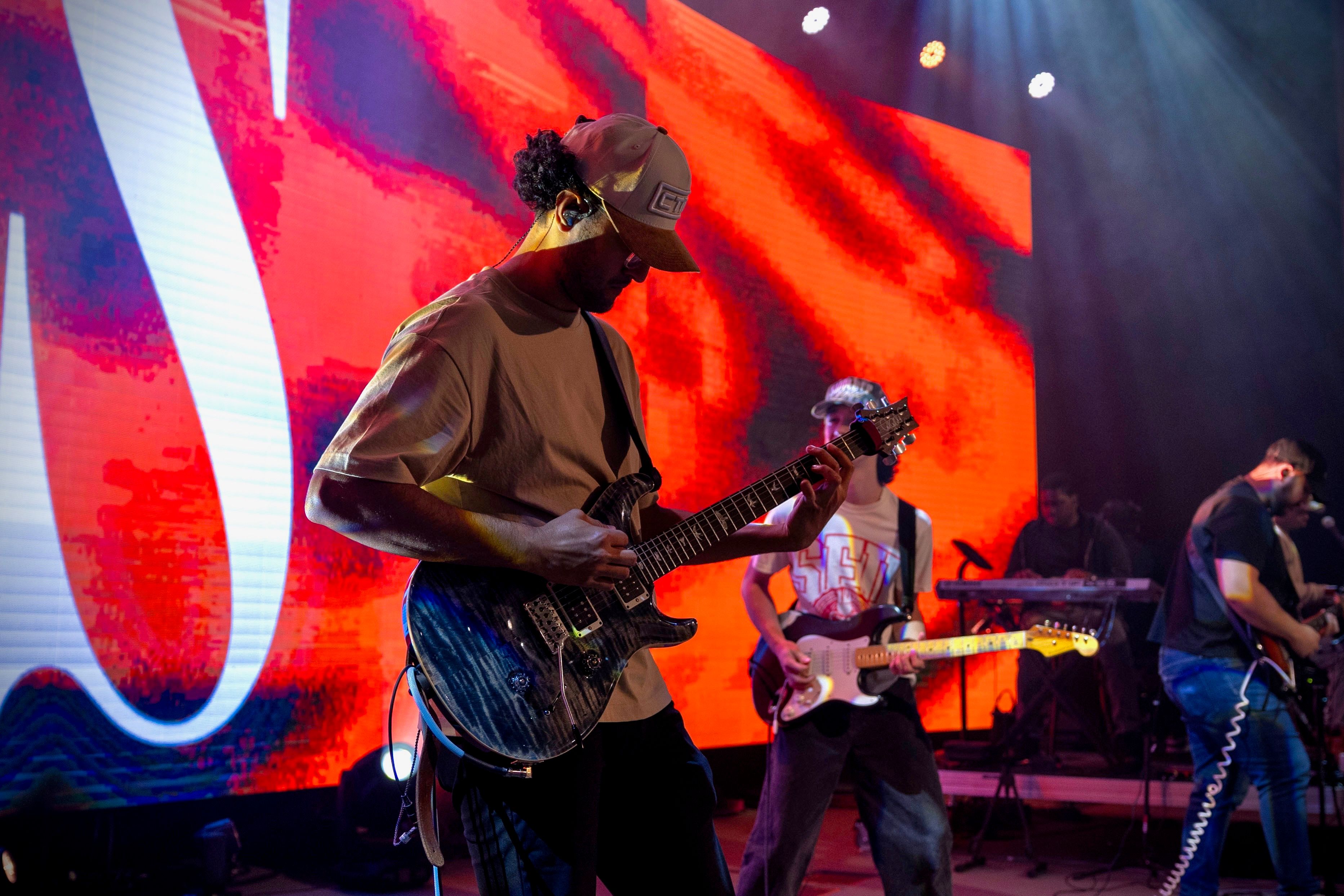 Guitarist in front of a red LED screen