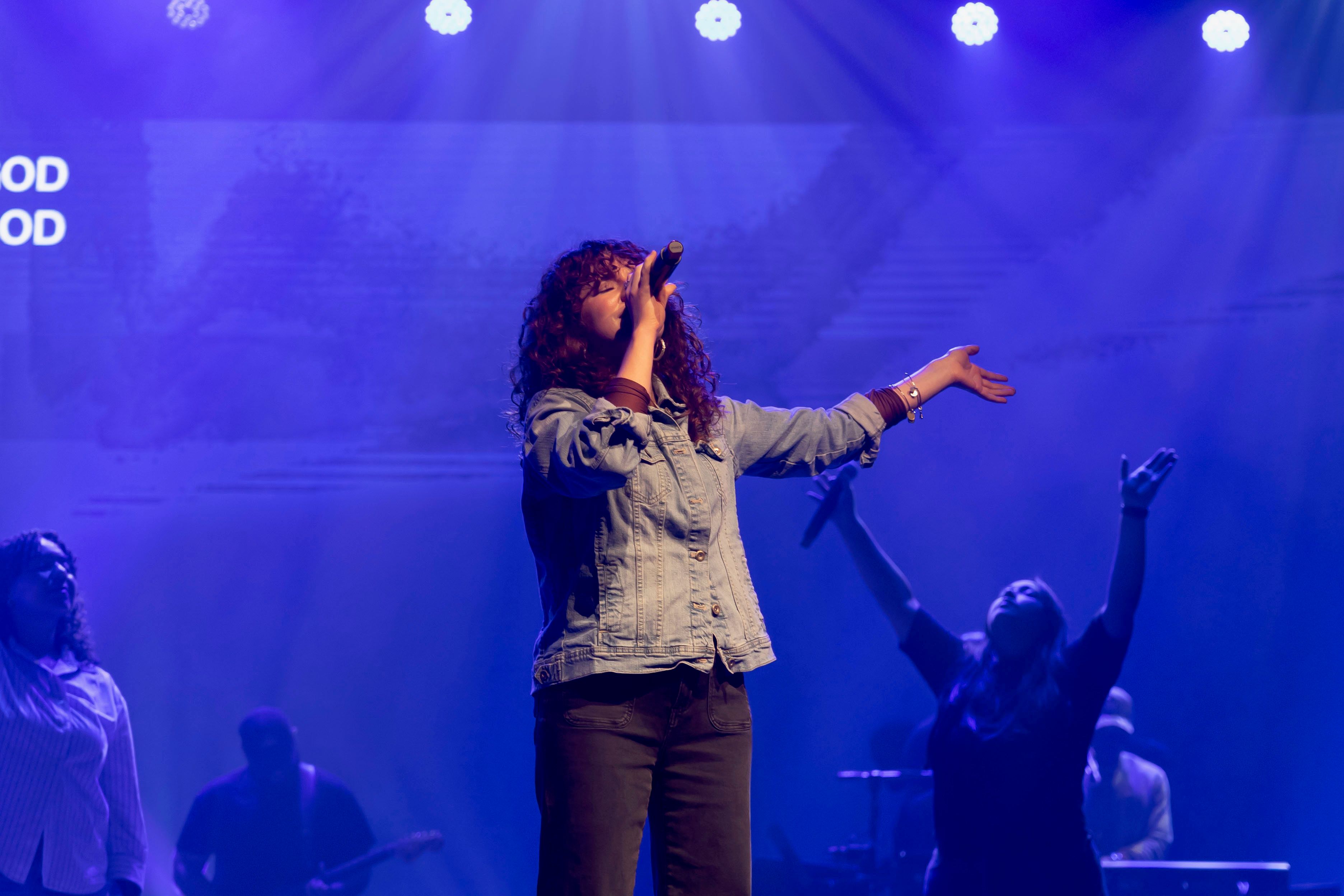 Vocalist singing under deep blue stage light